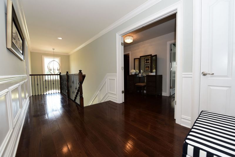 Image of Second floor hallway showing entrance to Master Bedroom and large chandalier in the two story foyer 