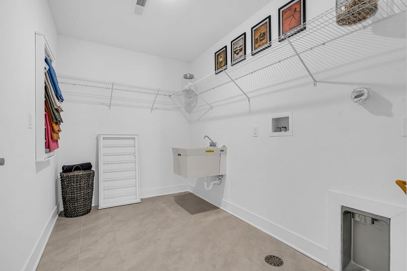 Interior photo of the Boulder model at the Grove at Woodhaven showcasing a walk-in closet with luxurious slate tile flooring and ample shelving for additional storage and laundry needs.